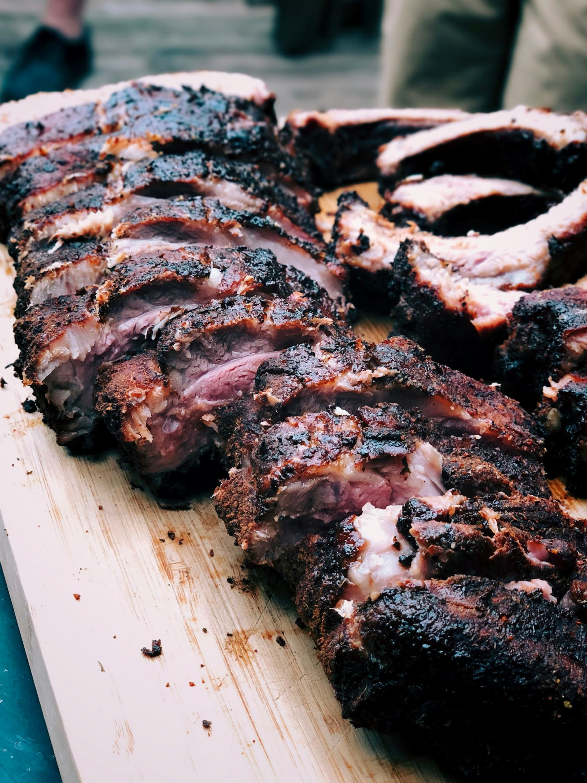 Sliced spare ribs on the cutting board, deep smoke ring under black-pepper bark